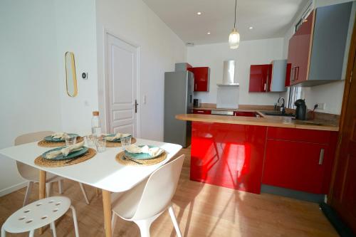 une cuisine avec une table blanche et des placards rouges dans l'établissement Magnifique haut de villa chez Charlotte, à Antibes