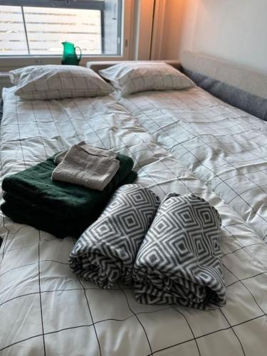a bed with four pillows on top of it at Kaikki palvelut aivan vieressä in Helsinki