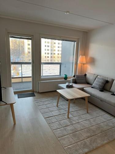 a living room with a couch and a coffee table at Kaikki palvelut aivan vieressä in Helsinki