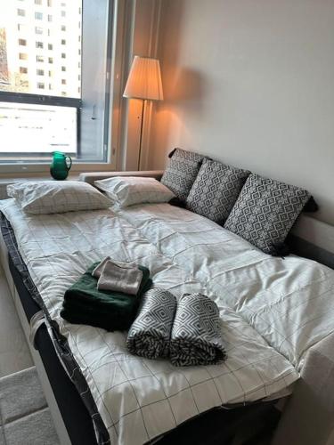 a bed with pillows on it in a bedroom at Kaikki palvelut aivan vieressä in Helsinki