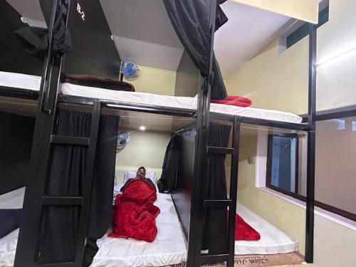 a person laying in a bed in a room with bunk beds at The Darsya Varanasi in Varanasi