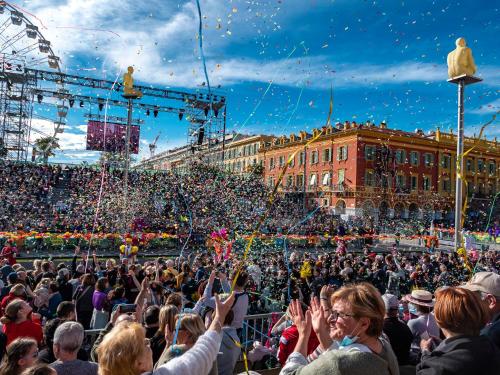a crowd of people standing in front of a carnival at Hôtel de France, un hôtel AMMI in Nice