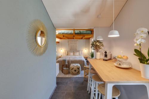 a room with a bed and a dining room with a table at Bijou du Lac - mit Pool und Privatstrand in Därligen