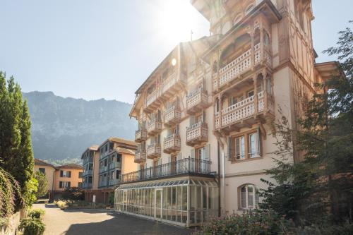 a large building with balconies on the side of it at Bijou du Lac - mit Pool und Privatstrand in Därligen