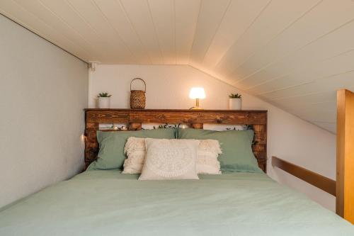 a bedroom with a green bed in a attic at Bijou du Lac - mit Pool und Privatstrand in Därligen