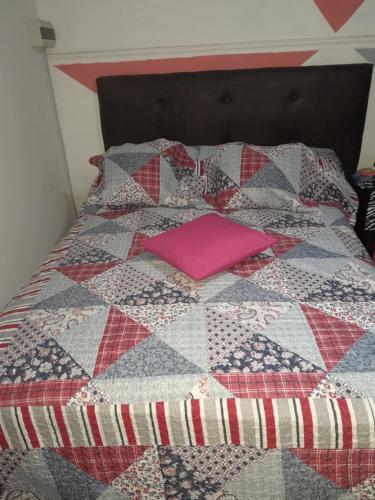 a bed with a pink pillow on top of it at El rosal ,descanso para viajeros in Junín