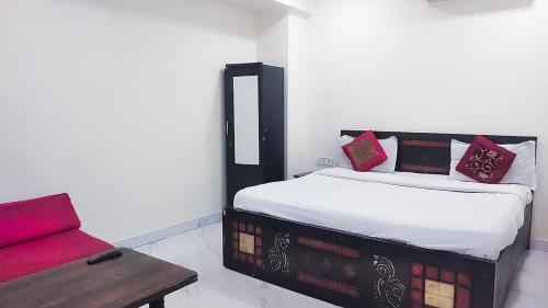 una camera con un letto e un divano rosso di Roomshala 161 Hotel Three Kings a Nuova Delhi