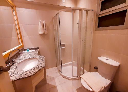 a bathroom with a shower and a toilet and a sink at Beau Site Hotel in Marsa Matruh