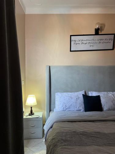 1 dormitorio con 1 cama grande y un cartel en la pared en Escape room, en Kampala