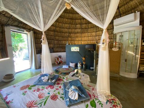 a bedroom with a large bed with a canopy at Cazhibiscus in Trou aux Biches
