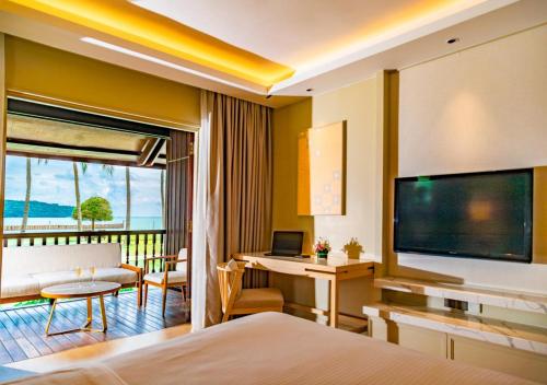 a hotel room with a bed and a television at Pelangi Beach Resort & Spa, Langkawi in Pantai Cenang