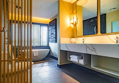 a bathroom with a tub and a sink at Pelangi Beach Resort & Spa, Langkawi in Pantai Cenang