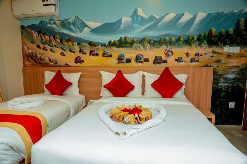2 Betten in einem Zimmer mit Wandgemälde in der Unterkunft Hotel Kedarnath in Kathmandu