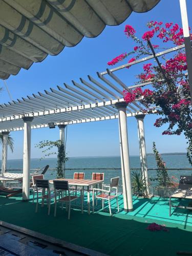 patio ze stołem i krzesłami oraz oceanem w obiekcie Trị An Villa w mieście Xã Trảng Bôm