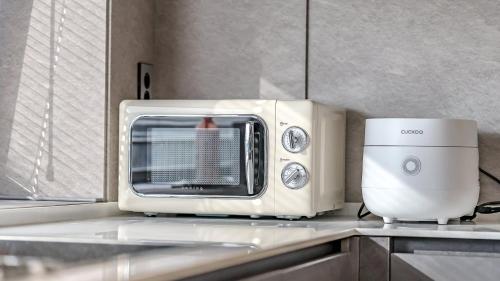 a microwave sitting on top of a kitchen counter at Jeju Family Garden Village in Jeju