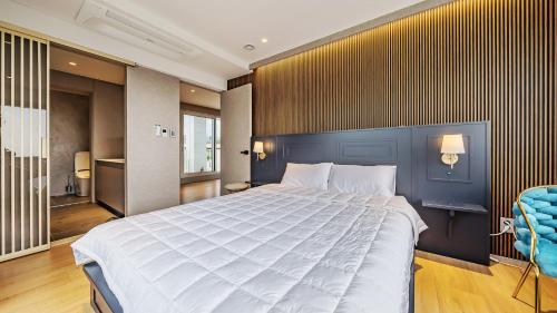a bedroom with a large bed and a blue wall at Jeju Family Garden Village in Jeju