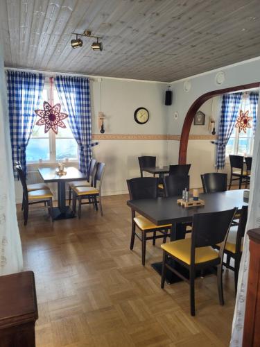 a dining room with tables and chairs and windows at Wärdshuset Klarälvdalen in Sysslebäck