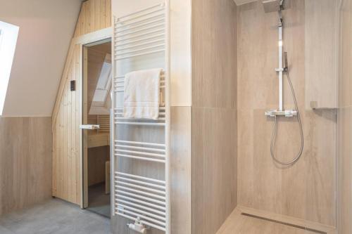 ein Bad mit einer Dusche und einem begehbaren Kleiderschrank in der Unterkunft Villa Dornkamp 4 - Luxuriöse Ferienwohnung für 4 Personen inklusive Balkon und Sauna in Timmendorfer Strand
