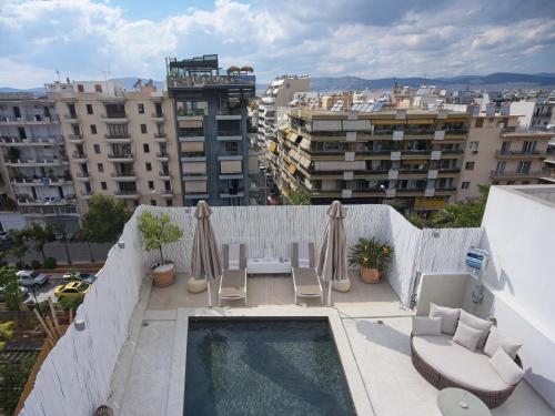 uma varanda com cadeiras e uma piscina num edifício em Ma Maison No5 Penthouse Loft, Private Heated Pool, Acropolis view, Ultra high speed Internet 300 Mbps, Short walk to Acropolis, Parking upon request, 1' from metro em Atenas