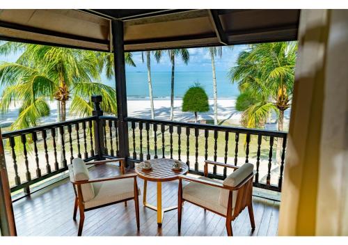 a table and chairs on a balcony with a view of the beach at Pelangi Beach Resort & Spa, Langkawi in Pantai Cenang