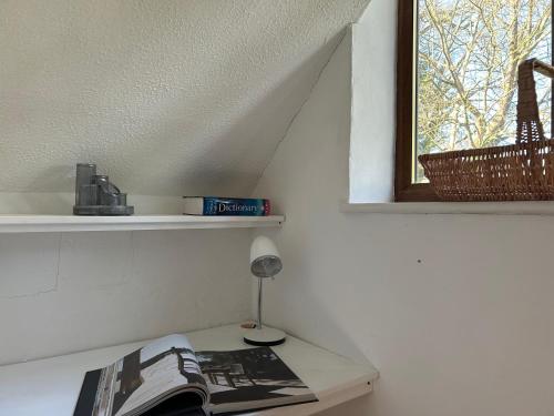 um quarto com uma mesa com um jornal e uma janela em Rural house 2BR 4 person 20 min f/beach, Rolvenden em Rolvenden