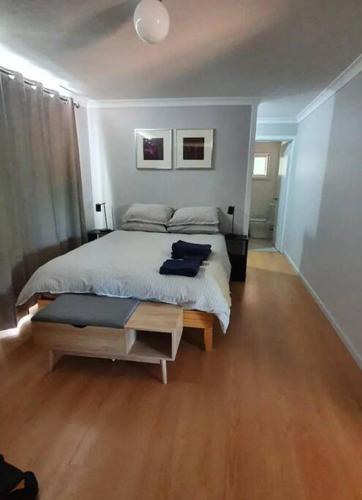 a bedroom with a large bed and a wooden floor at Begonia Cottage in Dwellingup