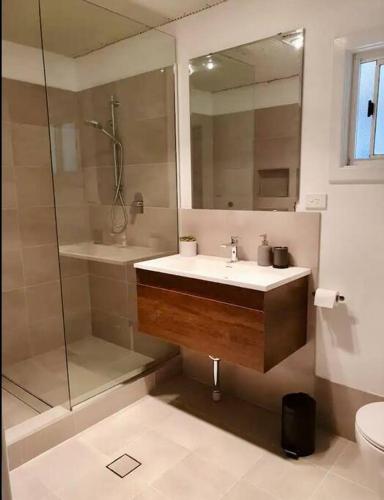 a bathroom with a sink and a shower at Begonia Cottage in Dwellingup