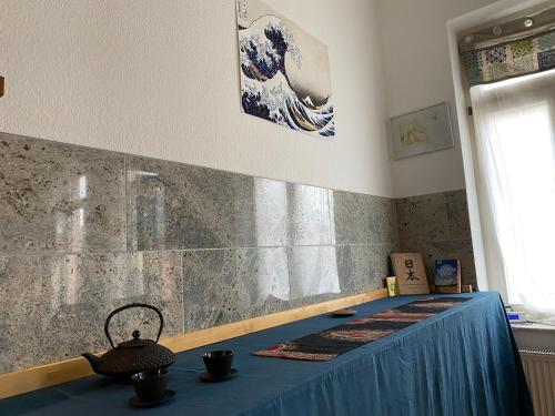 una mesa azul en una habitación con una ola en la pared en Schönes Jugendstil Appartement in bester Lage, en Leipzig