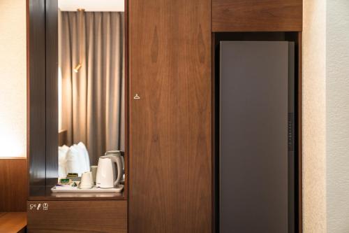 - une porte dans une chambre d'hôtel avec une cafetière dans l'établissement Uiwang Milos Hotel, à Uiwang
