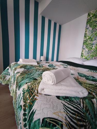 a bedroom with a bed with towels on it at Apartamenty Poddąbek- basen kryty, sauna, animacje dla dzieci , małpi gaj, baseny na dachu in Poddąbie