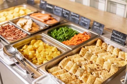 a buffet filled with different types of food in trays at IQ Hotel in Kyiv