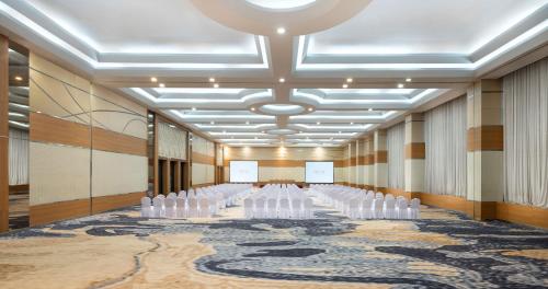 a conference room with white chairs on a carpet at Atria Hotel Magelang in Magelang