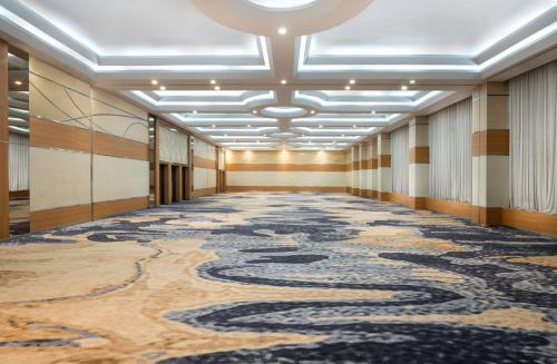 an empty hallway with a large rug on the floor at Atria Hotel Magelang in Magelang