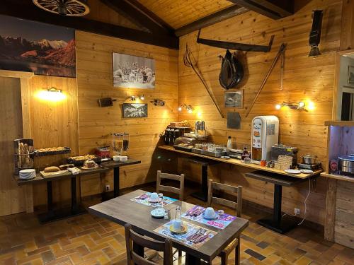 a kitchen with wooden walls and tables and chairs at Hotel Le Soly in Morzine