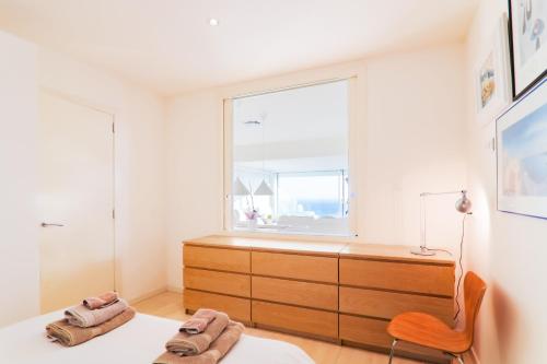 シッチェスにあるSitges Suites Bのベッドルーム1室(窓、ベッド1台、椅子付)