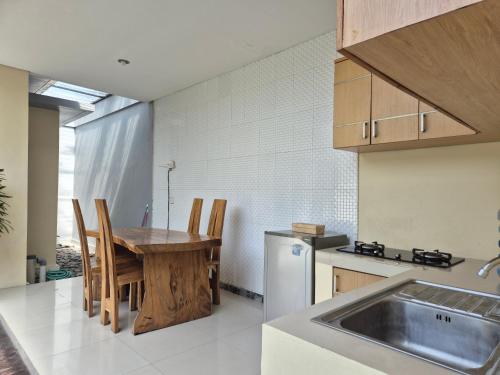 a kitchen with a table and chairs and a sink at The Bagus in Kerobokan