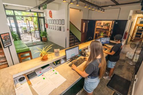 two people standing at a counter with a computer at Never at Home Kloof Street in Cape Town