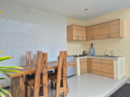 a kitchen with a wooden table and wooden cabinets at The Bagus in Kerobokan