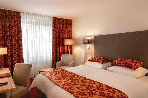 デュッセルドルフにあるホテル アストラの大きなベッドと窓が備わるホテルルームです。