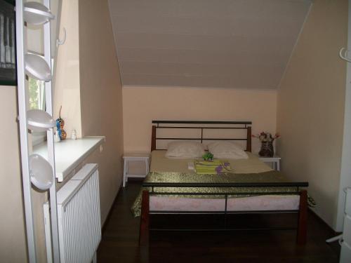 a small bedroom with a bed and a table at Ezerkiemis in Trakai