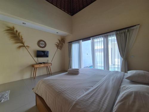 a bedroom with a large bed and a large window at The Bagus in Kerobokan