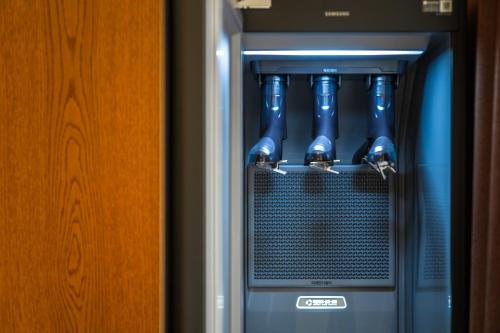 a refrigerator with blue water bottles in it at Uiwang Milos Hotel in Uiwang