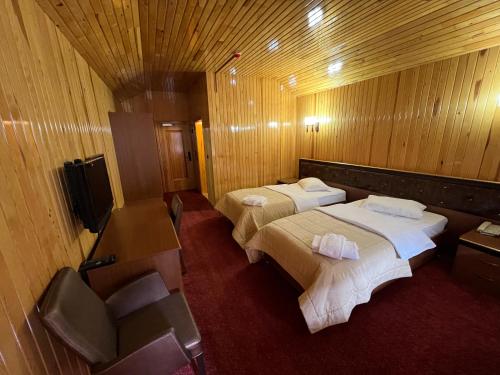 a hotel room with two beds and a television at Lahza Hills Resort in Çaykara