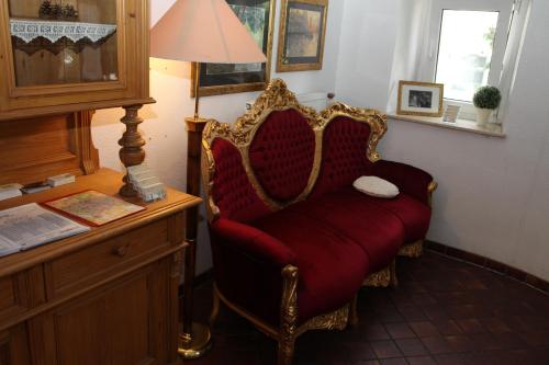 a red chair sitting in a room next to a desk at Hotel Alt-Erfurt in Erfurt