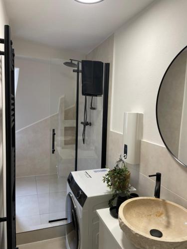 a bathroom with a sink and a shower with a mirror at Urban Retreat - Central and Historic with Private Parking in Würzburg