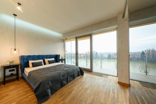 ウージュホロドにあるLuxury Apartments VENECIAの川の景色を望むベッドルーム1室(ベッド1台付)