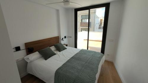 een slaapkamer met een bed en een groot raam bij Rutlla 10 in Girona