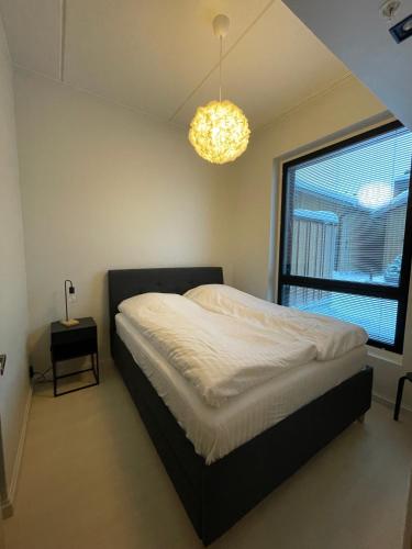a bedroom with a bed and a window and a chandelier at Levi Cranberry C1, ski-in ski-out 2 bedroom apartment in Levi center in Levi