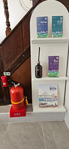 a shelf with a fire hydrant and books at Soban Stay in Busan