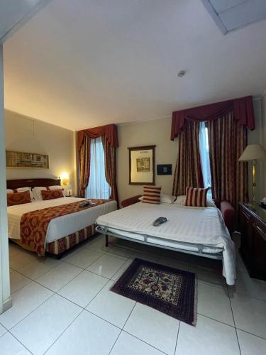 a hotel room with two beds and avisor at Hotel Villa Savoia in Turin